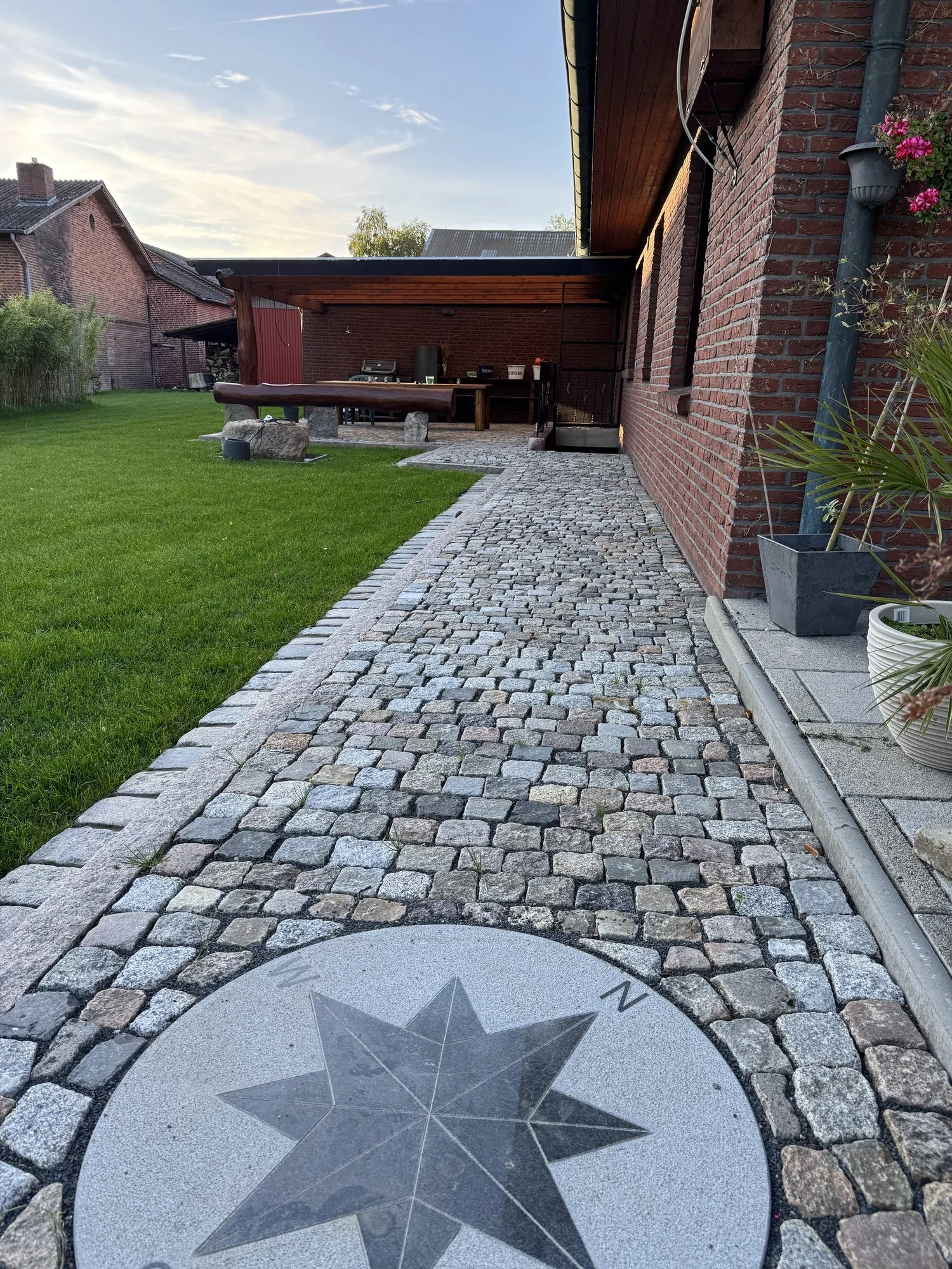 Natursteinweg mit eingelegter Windrose und gepflastertem Rand