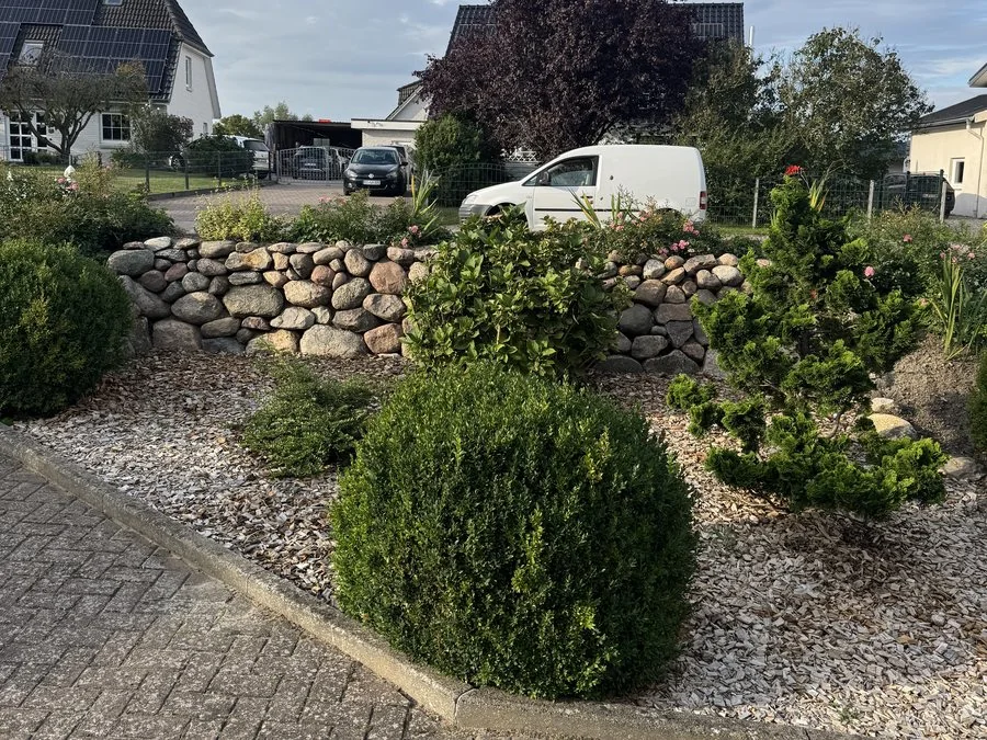 Friesenwall aus Natursteinen mit Bepflanzung und Kiesbeet